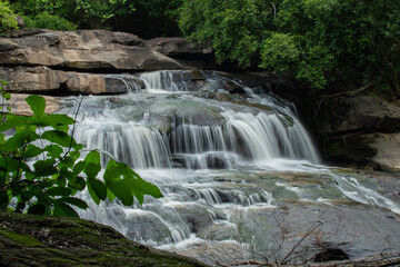 Fototapeta premium small waterfall In the midst of nature, blurry branches