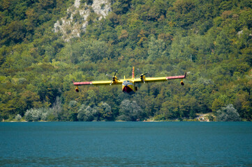 Fototapeta na wymiar Canadair in fase di ricarica presso il lago di Cavazzo, Udine, Italia