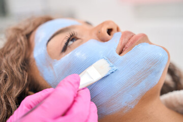 Beautiful woman on alternative facial cleansing procedure in cosmetology clinic