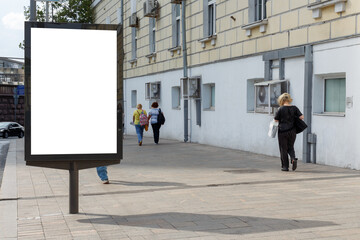 Vertical billboard for advertising and text in the city. Several pedestrians during the day. Mock-up.