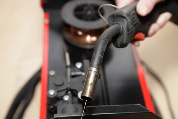 Fototapeta Welding gun torch on Semi-automatic welding machine with opened cover background obraz