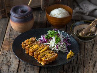 Menchi katsudon with white rice and salad served in a dish isolated on wooden background side view of japanese food