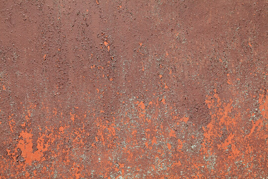 Metall wall, background, texture. Rusted metallic backdrop. An old red and rusty surface with faded uneven color. Abstract rust pattern on a fulvous (lurid) surface. The wall and fence sketches