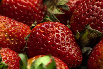 fresh strawberries on wooden base and dark background