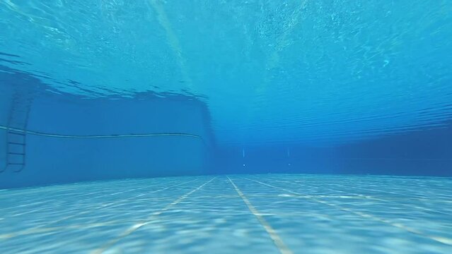 Underwater shot of an clean empty inside of the swimming pool. blue water background with copy space..