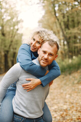 Fototapeta premium Romantic couple standing in a forest, hugging and posing for a photo