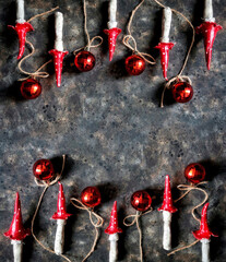 A pattern of handmade fly agarics and christmas balls on black concrete background with copy space. Beautiful background of clay toadstools. Christmas concept.