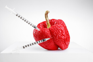 Wrinkled, withered red pepper with syringes. Concepts of healthcare or cosmetology, anti aging skin...