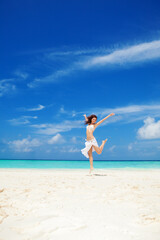 Happy young woman jumping on the beach. White sand, blue cloudy sky and crystal sea of tropical beach. Vacation. Ocean beach relax, travel to islands. Happy lifestyle. - 518993568