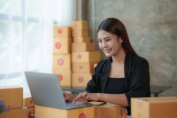 Online business owner Asian woman are using computer to check orders and customer addresses so that they can be delivered to their customers correctly.