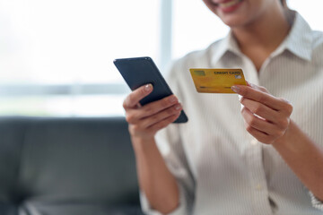 Woman hand holding smartphone shopping online with credit card. Online Payment. Online shopping concept.