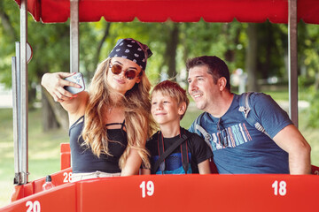 Hipster family taking selfie on open-air buss during tour ride adventure - 518994787