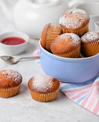 Homemade muffins with  teapot, cream and jam on the table