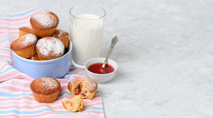 Homemade muffins with filling, milk and jam on a white table with copy space
