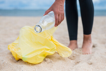 girl collects plastic bottles with garbage on the beach to save the cleanliness of the planet and ecology