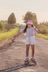 happy girl on roller skates in summer road