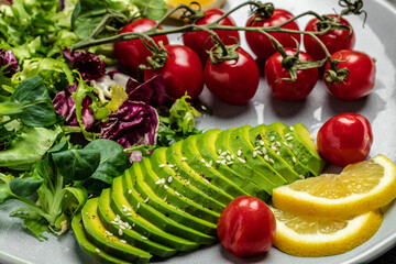 Tuna fish salad on light background. Lettuce, cherry tomatoes, avocado and red onions. Clean healthy detox eating. Vegan vegetarian food. Making healthy salad. top view