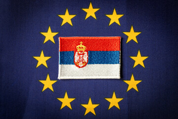 The flag of Serbia against the background of the Symbol of the European Union, the concept of the Serbian desire to join the European Community