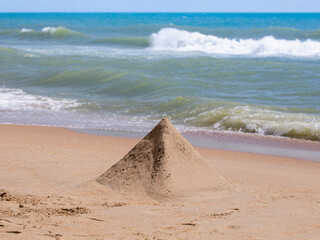 sand pyramid on the background of the sea.