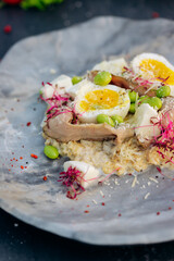 Oatmeal with boiled egg, bacon and green peas. Healthy and tasty breakfast
