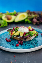 Whole wheat toasted bread with avocado, poached egg, soft cheese and mix salad. Healthy diet food breakfast