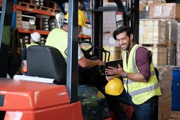 Fototapeta na wymiar Skillful worker drives forklift in the factory .men labor worker at forklift driver position with safety suit and helmet happy smile enjoy working in industry factory logistic shipping warehouse.