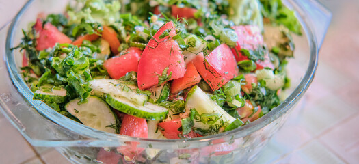 Salad of fresh vegetables and herbs, with vegetable oil. Close-up.