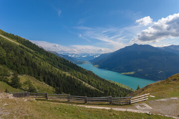 Fototapeta na wymiar Awesome summer aerial panorama of Resia Lake with Ortles massif in the background. Resia Pass, Alto Adige Sudtirol, Italy