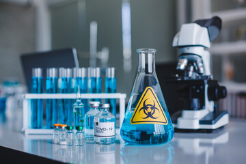 Set of COVID-19 vaccine chemical with microscope and test tube in the background in laboratory. Coronavirus or covid-19 concept.