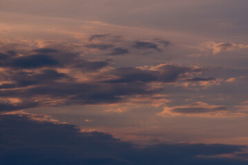 Background with dark clouds lit by the warm light of the setting sun.