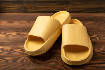 Stylish rubber slippers on a brown wooden background.Changeable shoes.Beach shoes.Copy space. Place for text.