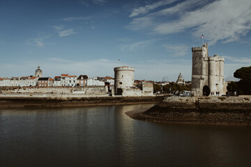 view to the castle and towers of la rochelle in france on the atlantic coast with a river and blue...