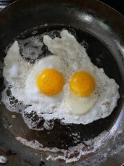 Two eggs frying for breakfast in the carbon steel pan