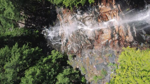 Drone Flying Down Rock Cliff with Waterfall Slow Motion
