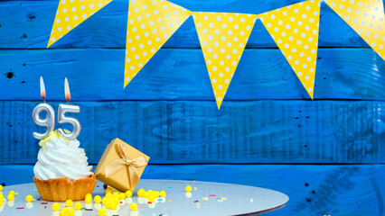 Beautiful card happy birthday with a cake with a number of candles on the background of blue vintage boards. Copy space. Happy birthday greetings with number 95