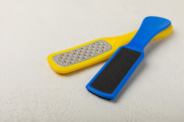 Foot file and grater on white marble background. Foot skin care product. Pumice stone file to remove dead skin from feet. Care and beauty concept. Copy space.