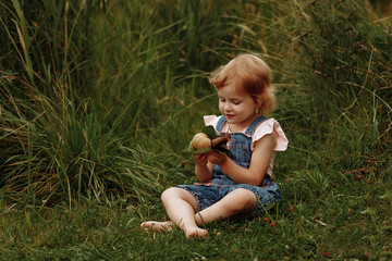 Girl petting a big snail on a tree