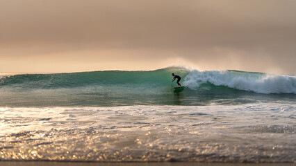Surfer rides off a smaller wave on beach at atlantic ocean 