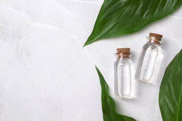 Little glass vial of aroma essential oil wich green leaves. Face serum in bottle. Hyaluronic acid...