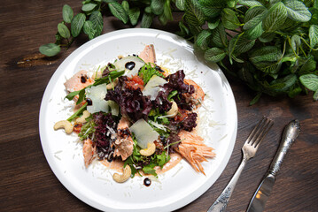 portion of salad with trout (salmon, red fish meat) and grapefruit and cashews. top view.