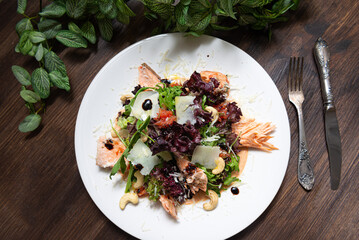 portion of salad with trout (salmon, red fish meat) and grapefruit and cashews. top view.