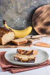 Pieces of banana bread on a plate on the table. Homemade breakfast. Vertical view