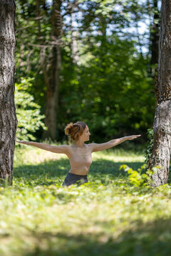 young woman performing yoga in forest