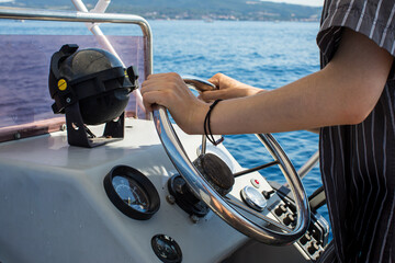 Driving motorboat on holiday. Man sailing an inflatable rubber motor boat on the sea. Boat rental...