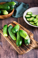 Ripe cucumbers on a cutting board on the table. Organic diet food. Vertical view