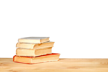 Old schoolbooks lying on a wooden school desk in front on a white background. Education concept - the desk in the auditorium. back to school concept