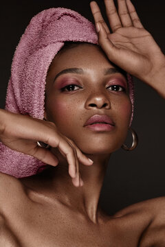 Beautiful black woman with a pink towel on her head and classic makeup. Beauty face.