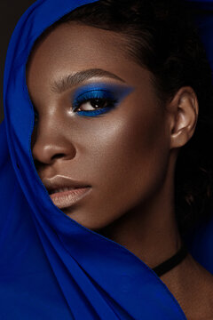 Beautiful black woman with blue fabric and classic art make-up. Beauty face.