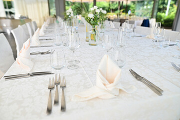 Wedding celebration table settings with floral arrangements taken in a light airy space.