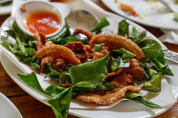 Thin sliced crunchy pork belly with kaffir lime leaves and spicy sauce.  